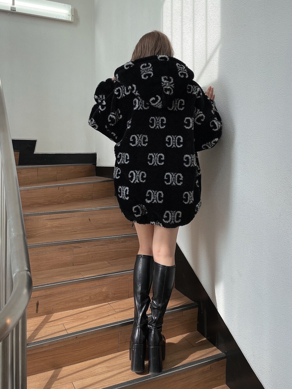 ブラック系のニット/セーター、ブラック系のブルゾン、ブラック系のブーツを着用したレディースの秋コーディネートの2枚目の写真