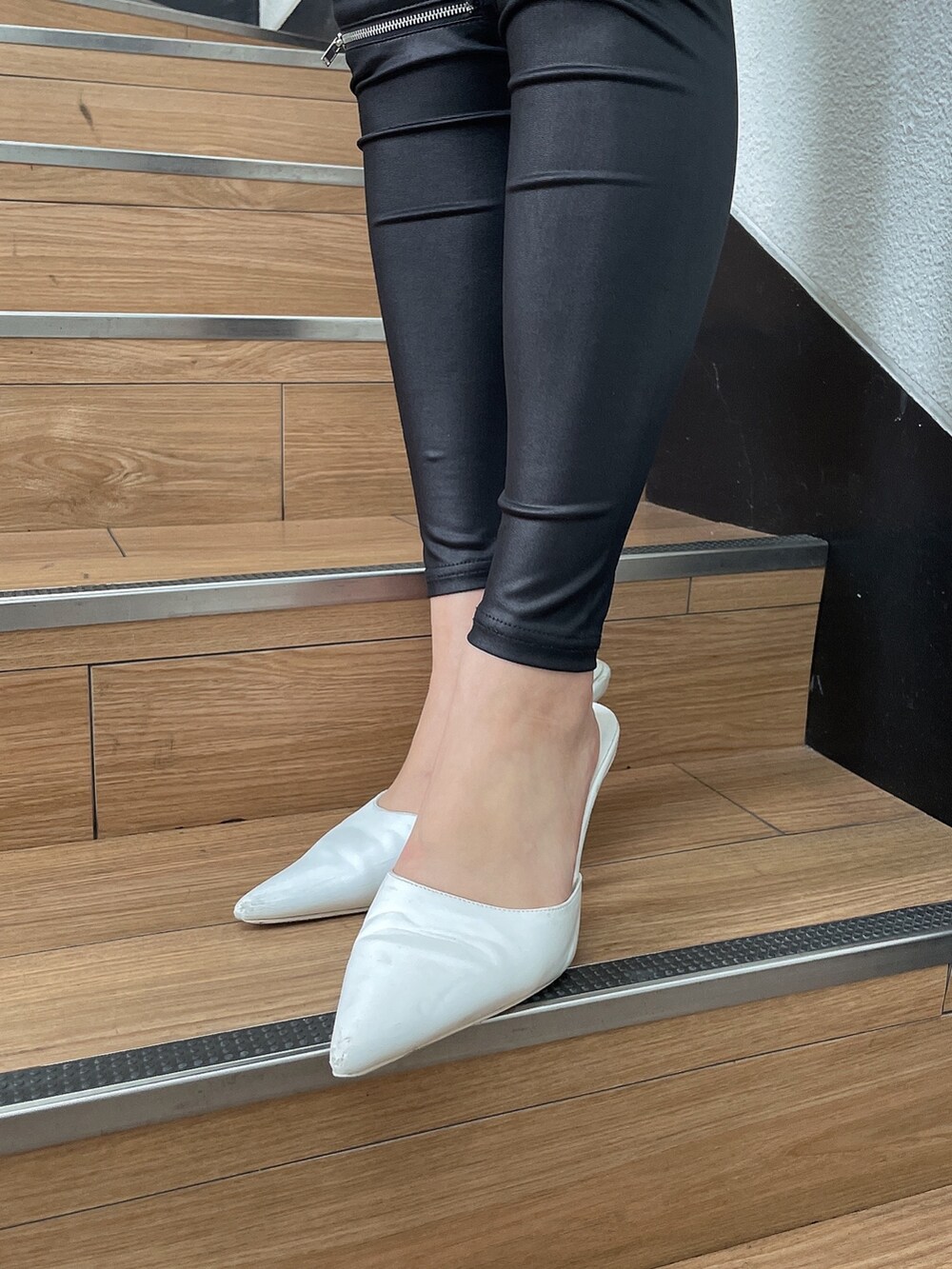 ブルー系のニット/セーター、ブラック系のその他パンツ、ホワイト系のパンプスを着用したレディースの冬コーディネートの7枚目の写真