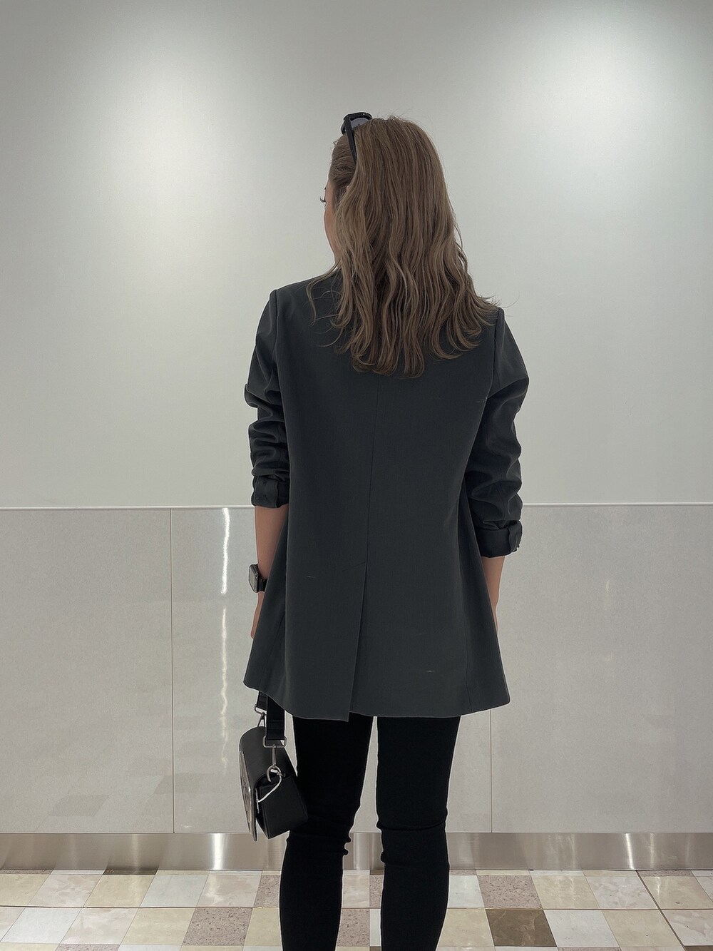 ブラック系のブーツ、ブラック系のデニムパンツ、ブラック系のハンドバッグを着用したレディースの秋コーディネートの4枚目の写真