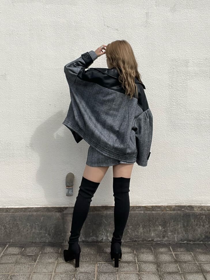 ブラック系のライダースジャケット、ホワイト系のニット/セーター、ブラック系のスカートを着用したレディースの秋コーディネートの3枚目の写真