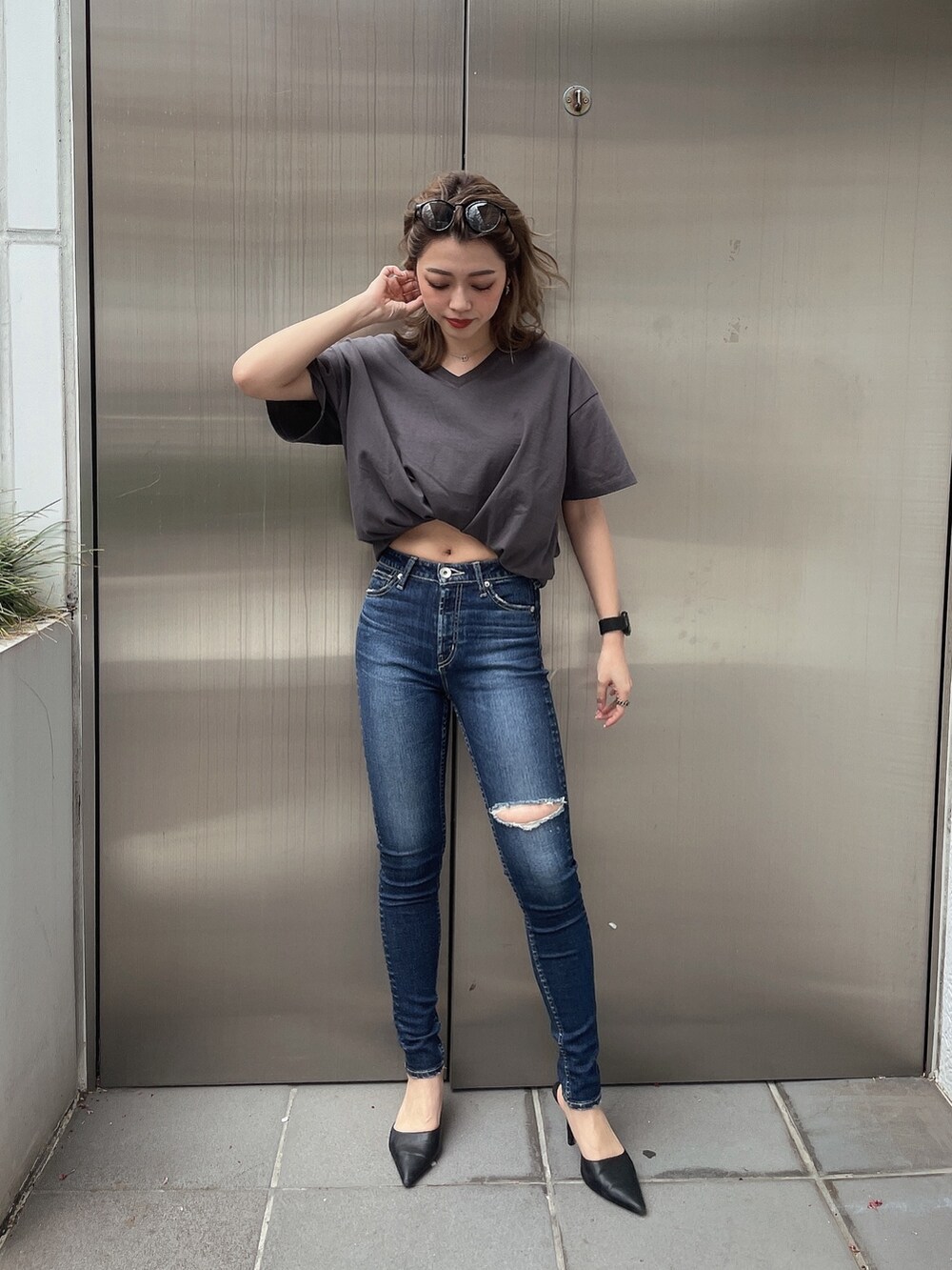 グレー系のTシャツ/カットソー、ブルー系のデニムパンツ、ブラック系のパンプスを着用したレディースの春コーディネートの2枚目の写真