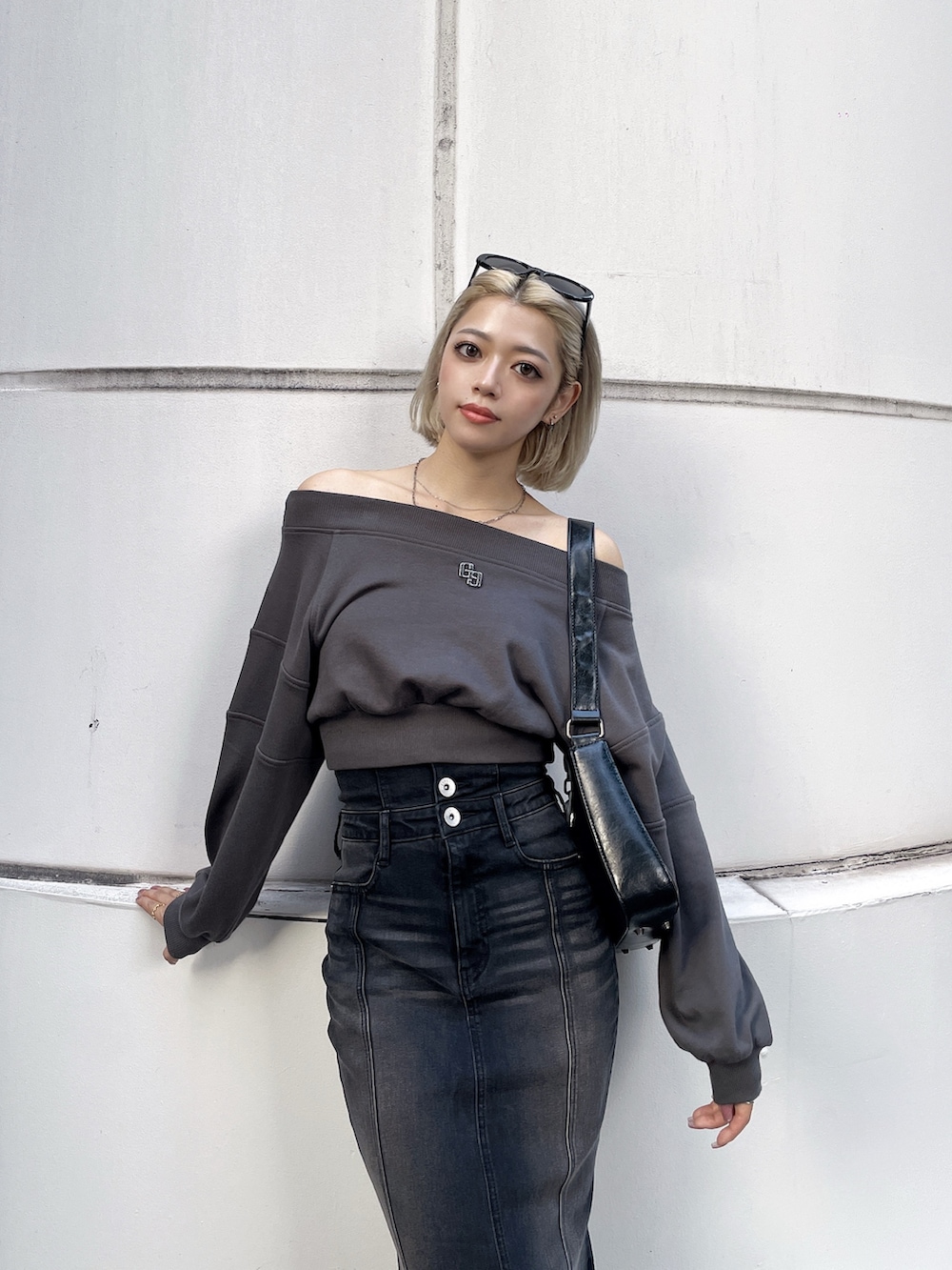 グレー系のTシャツ/カットソー、ブラック系のデニムスカート、ブラック系のハンドバッグを着用したレディースの秋コーディネートの2枚目の写真