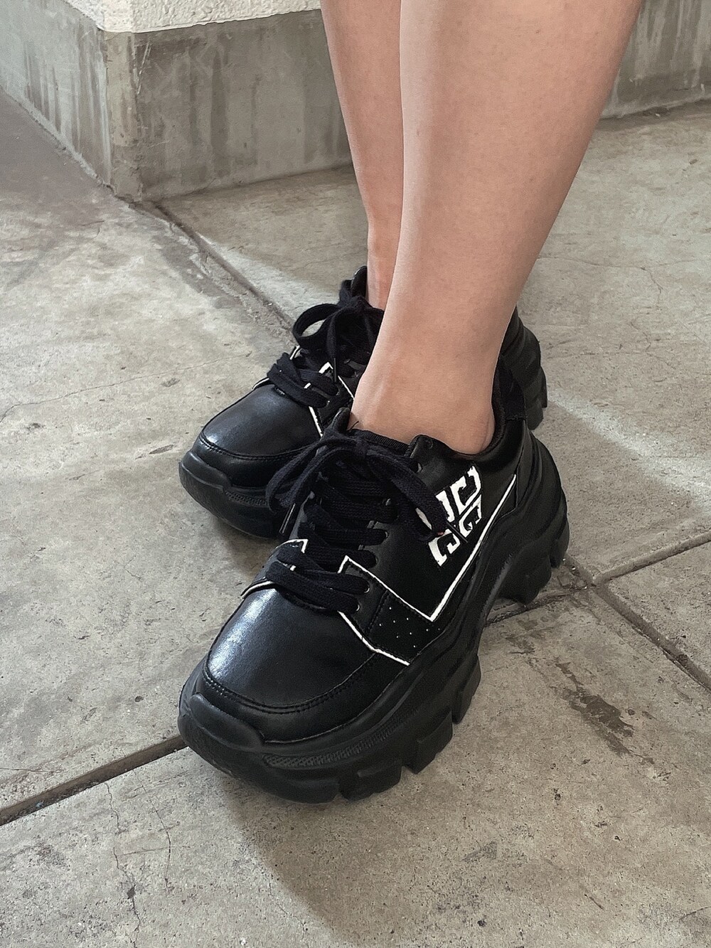 ブラック系のブルゾン、ブルー系のデニムスカート、ブラック系のスニーカーを着用したレディースの秋コーディネートの9枚目の写真