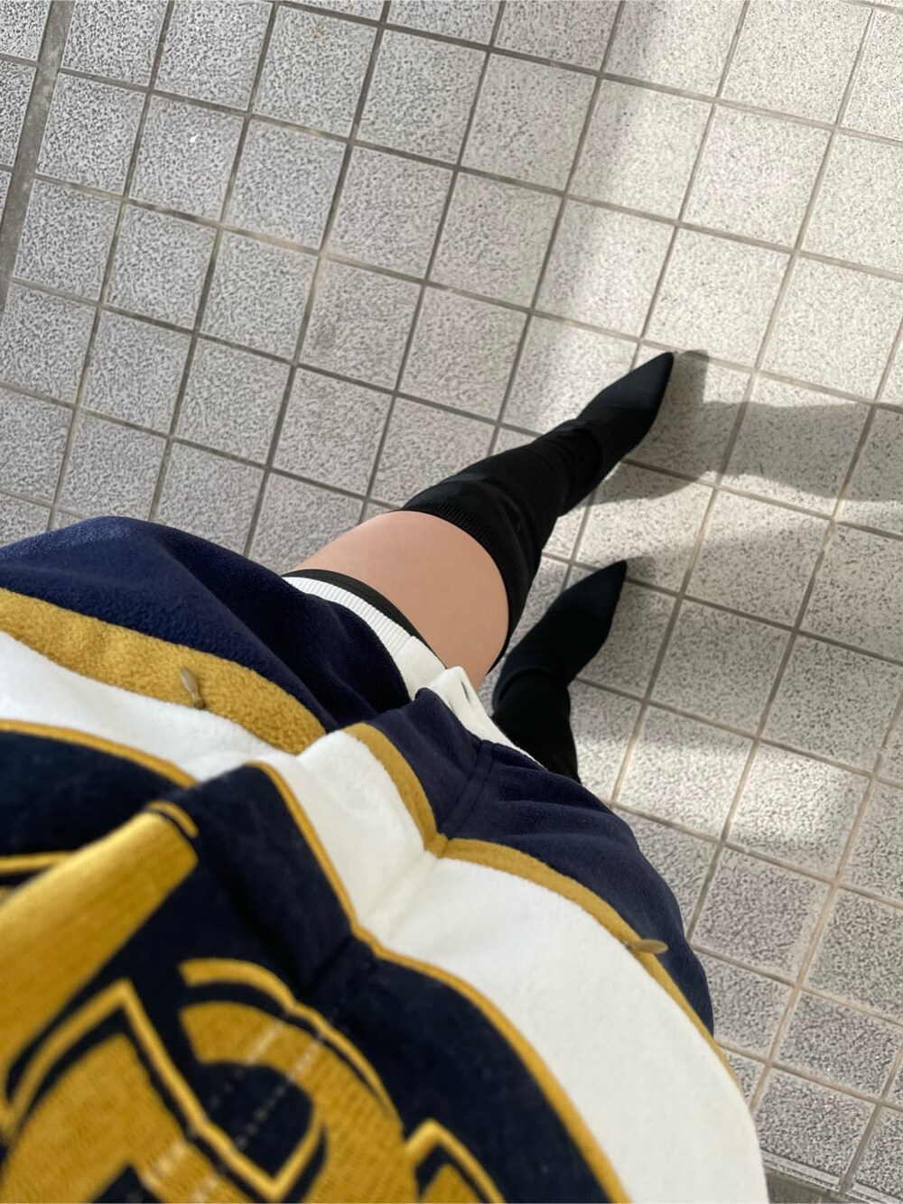 ホワイト系のブルゾン、ブラック系のブーツを着用したレディースの秋コーディネートの7枚目の写真