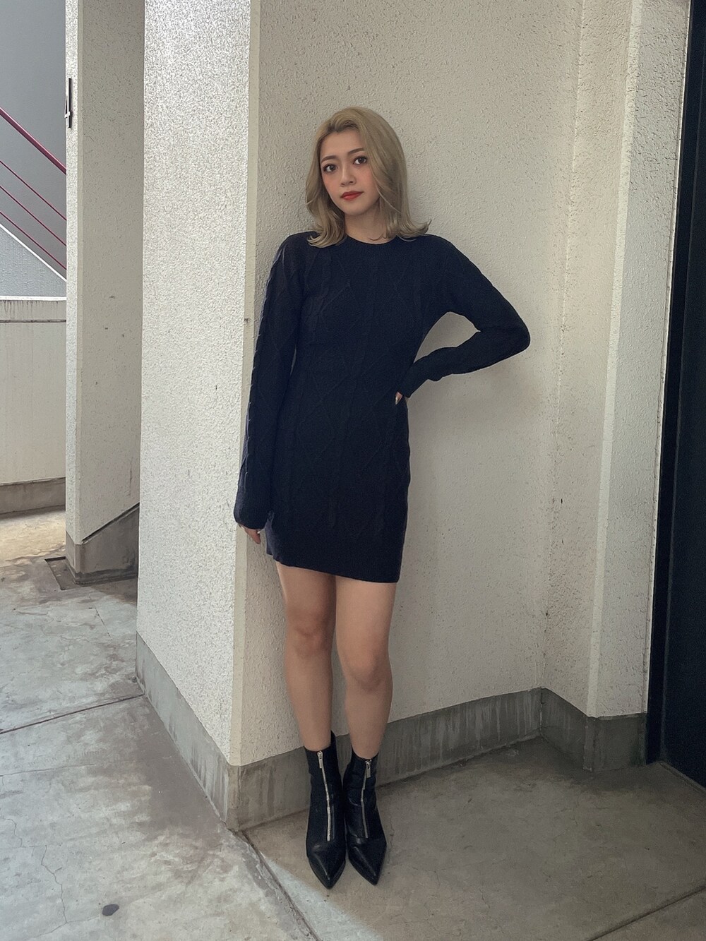 ブラック系のワンピース、ブラック系のブーツを着用したレディースの秋コーディネートの2枚目の写真