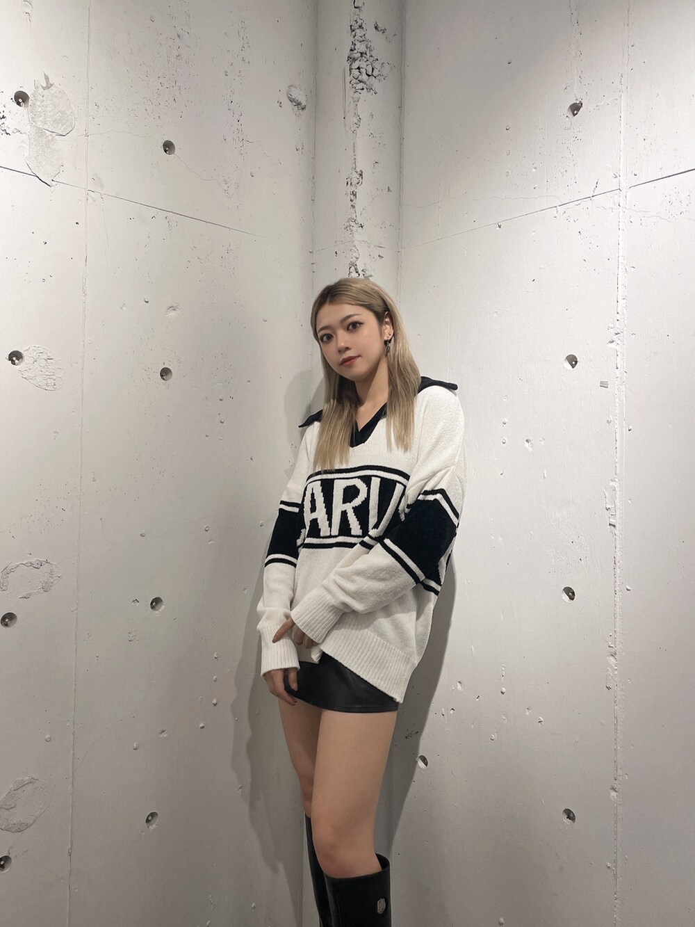 ホワイト系のニット/セーター、ブラック系のスカート、ブラック系のブーツを着用したレディースの秋コーディネートの4枚目の写真