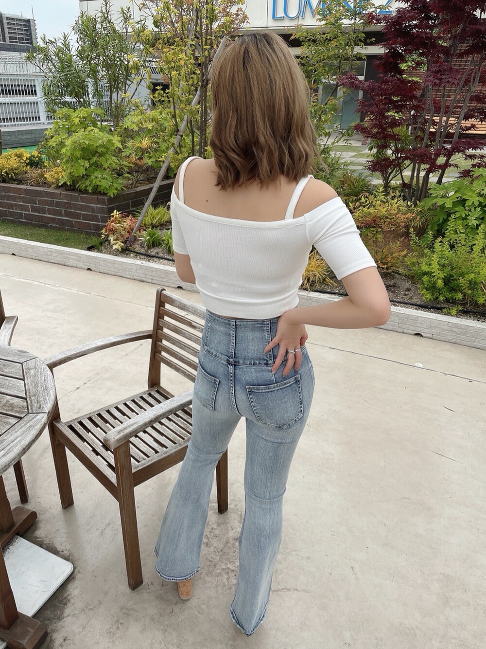 ホワイト系のTシャツ/カットソー、ブルー系のデニムパンツ、ベージュ系のサンダルを着用したレディースの春コーディネートの3枚目の写真