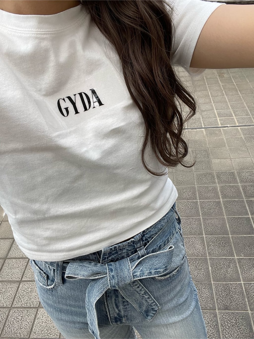 ホワイト系のサンダル、ホワイト系のTシャツ/カットソー、ブルー系のデニムパンツを着用したレディースの春コーディネートの3枚目の写真