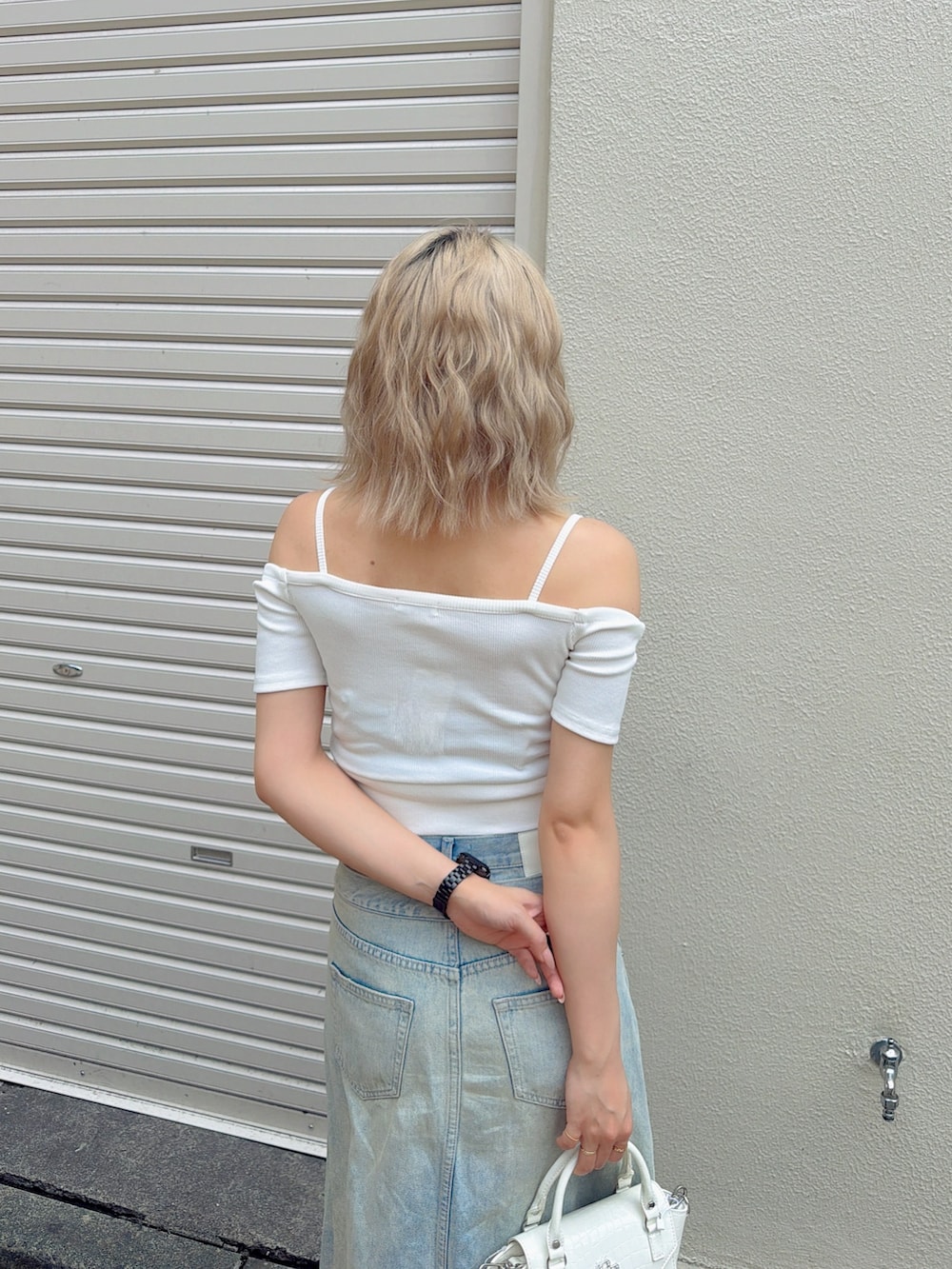 ホワイト系のTシャツ/カットソー、ブルー系のデニムスカート、ホワイト系のサンダルを着用したレディースの夏コーディネートの4枚目の写真