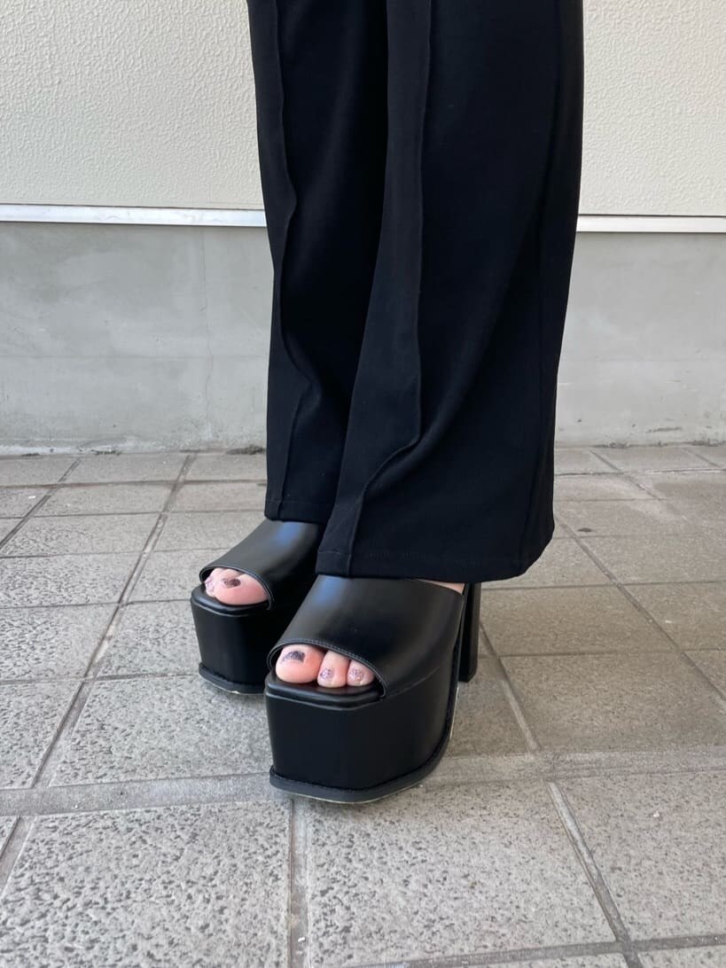 ブラック系のサンダル、ブラック系のデニムパンツ、ブラック系のタンクトップを着用したレディースの夏コーディネートの6枚目の写真
