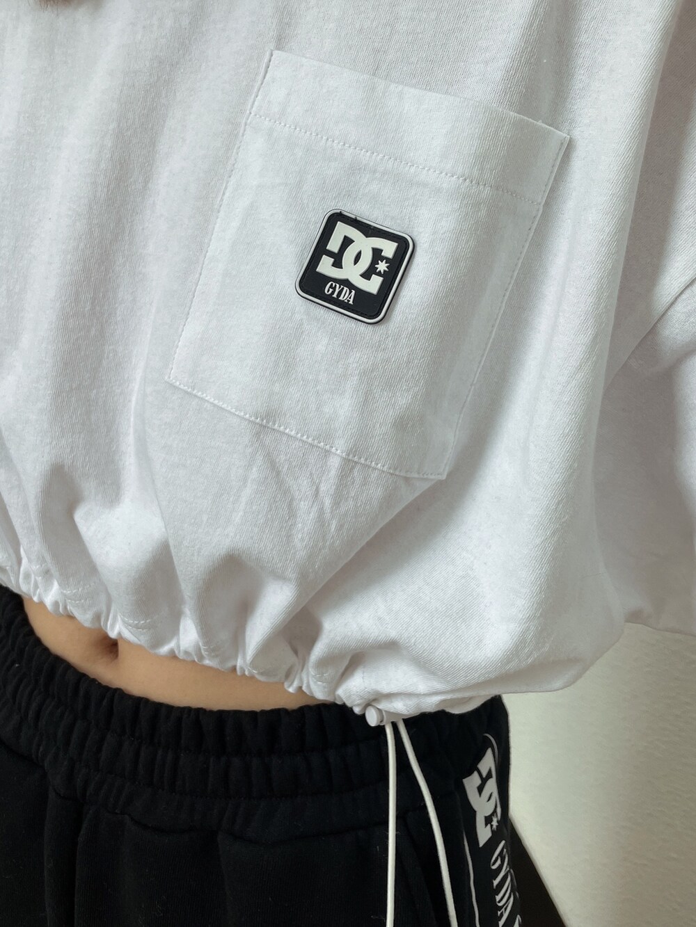 ホワイト系のTシャツ/カットソー、ブラック系のスウェットパンツ、ホワイト系のパンプスを着用したレディースの春コーディネートの8枚目の写真