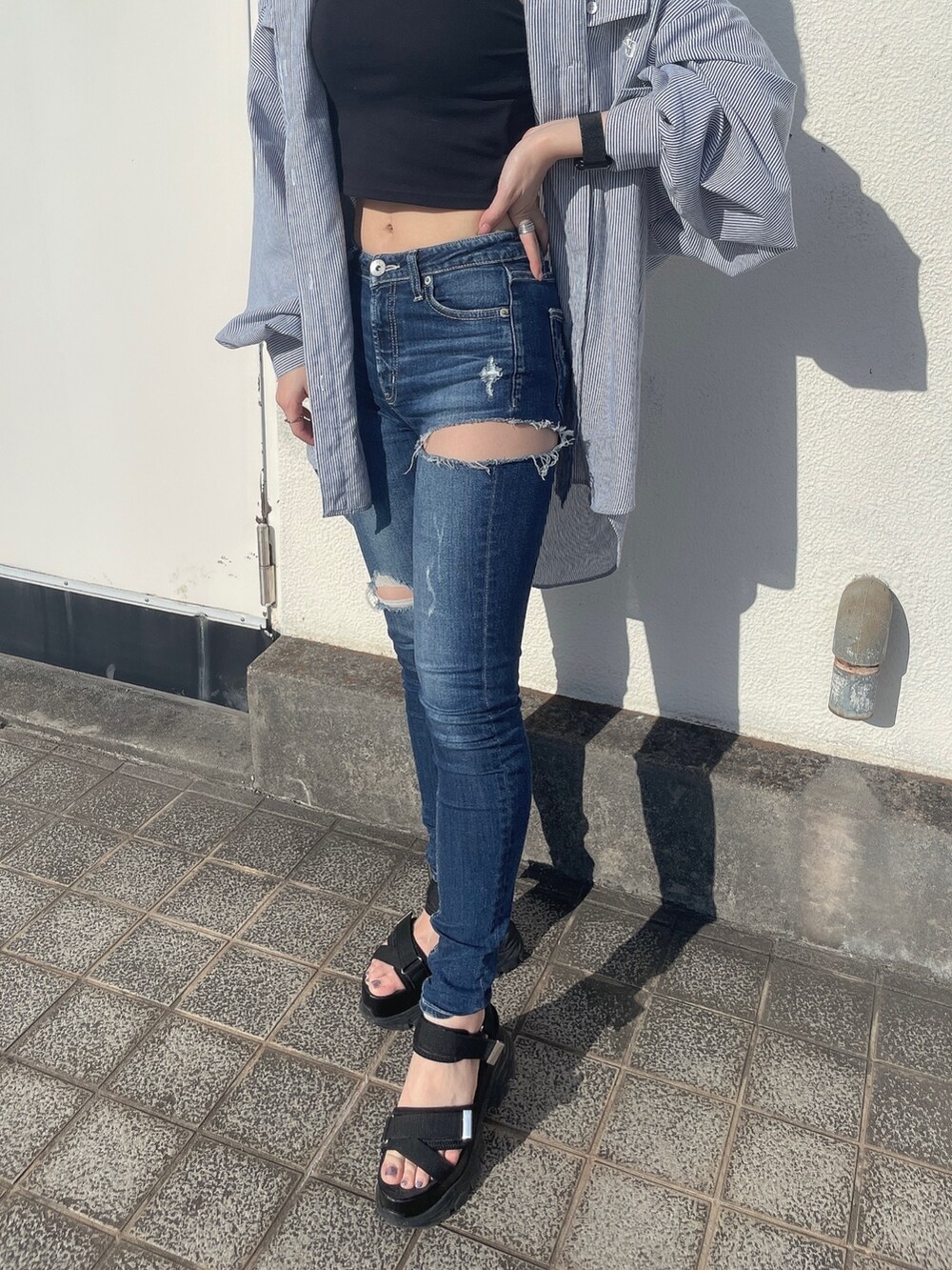 ブルー系のシャツ/ブラウス、ブルー系のデニムパンツ、ブラック系のサンダルを着用したレディースの春コーディネートの5枚目の写真