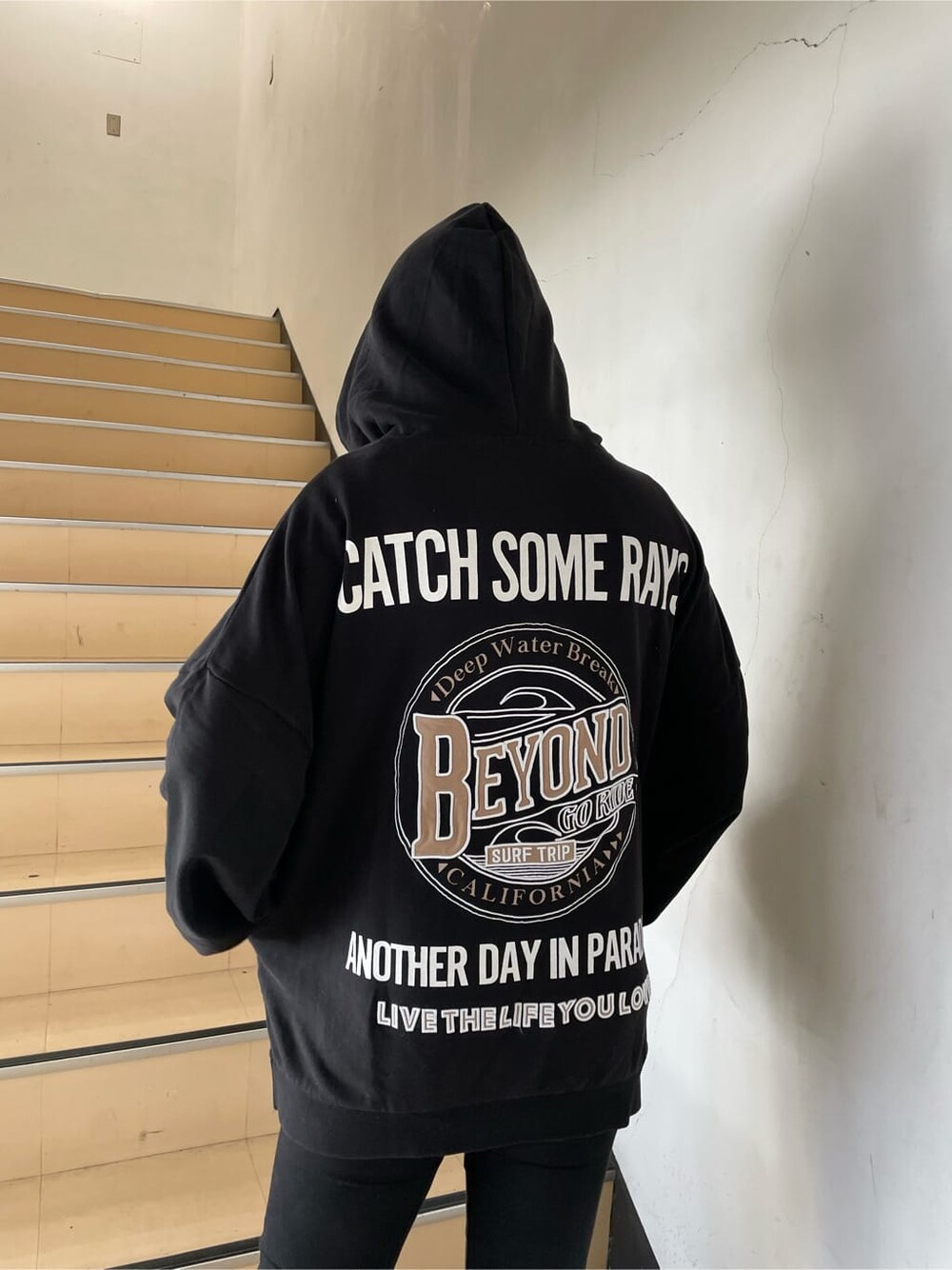グレー系のパーカー、ブラック系のブーツ、ホワイト系のTシャツ/カットソーを着用したレディースの冬コーディネートの2枚目の写真