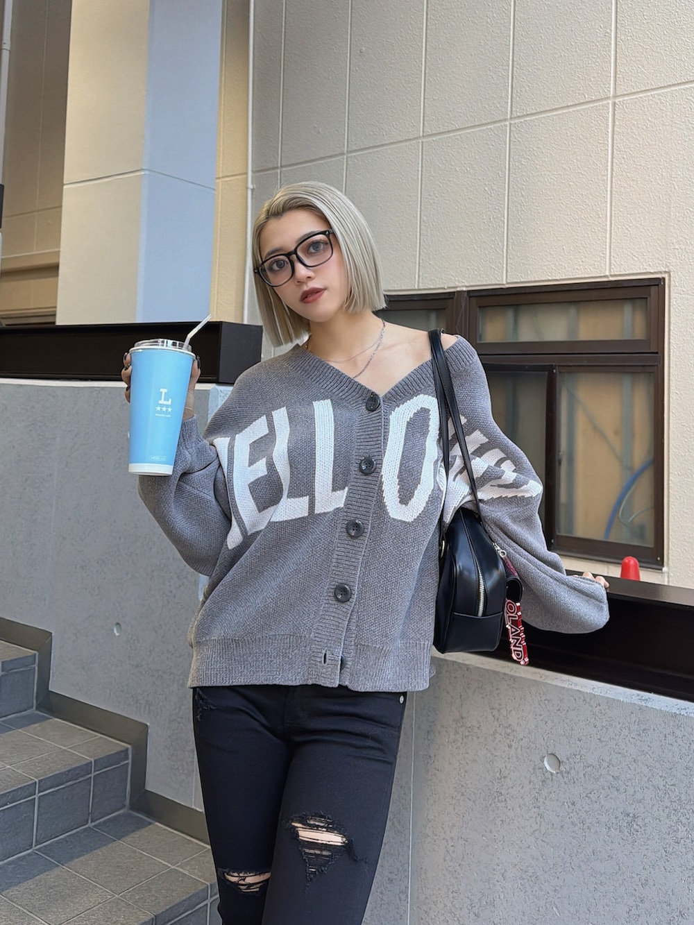 グレー系のカーディガン/ボレロ、ブラック系のデニムパンツ、ブラック系のブーツを着用したレディースの冬コーディネートの3枚目の写真