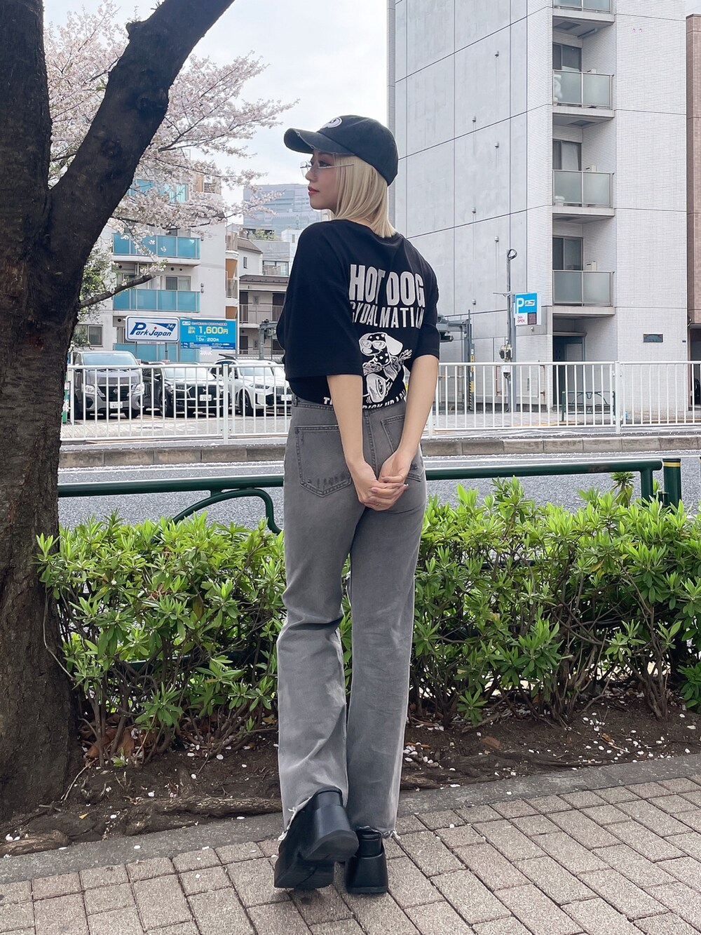 ブラック系のTシャツ/カットソー、グレー系のデニムパンツ、ブラック系のサンダルを着用したレディースの春コーディネートの2枚目の写真