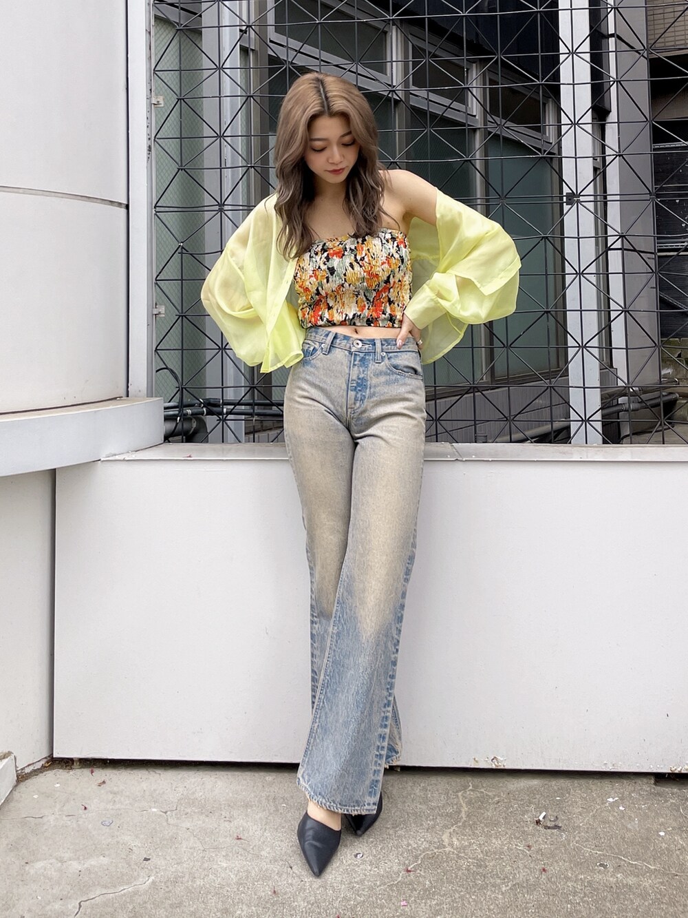 イエロー系のシャツ/ブラウス、ブラック系のチューブトップ、ブルー系のデニムパンツを着用したレディースの春コーディネートの2枚目の写真
