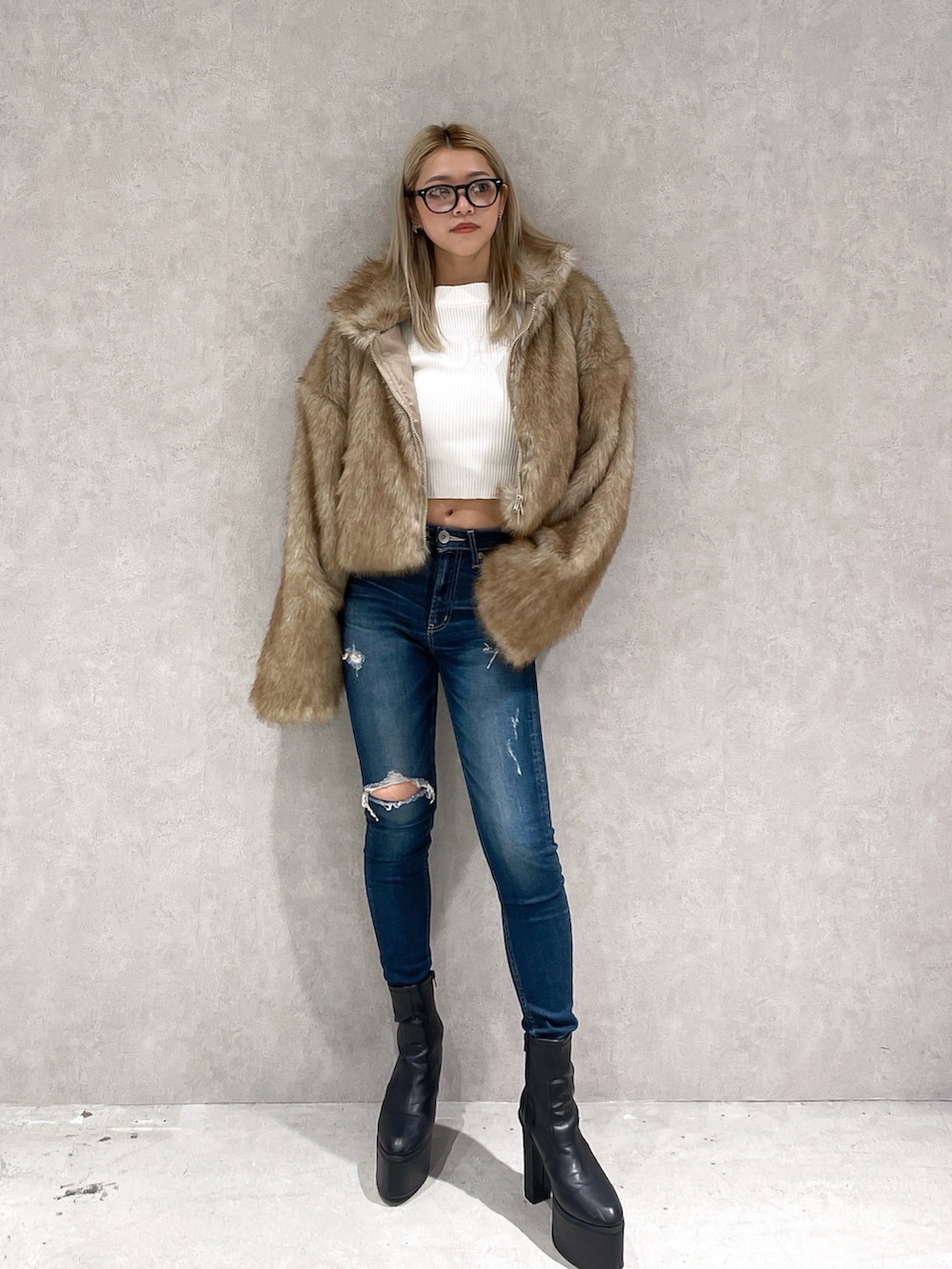 ベージュ系のその他アウター、ホワイト系のニット/セーター、ブルー系のデニムパンツを着用したレディースの冬コーディネートの2枚目の写真