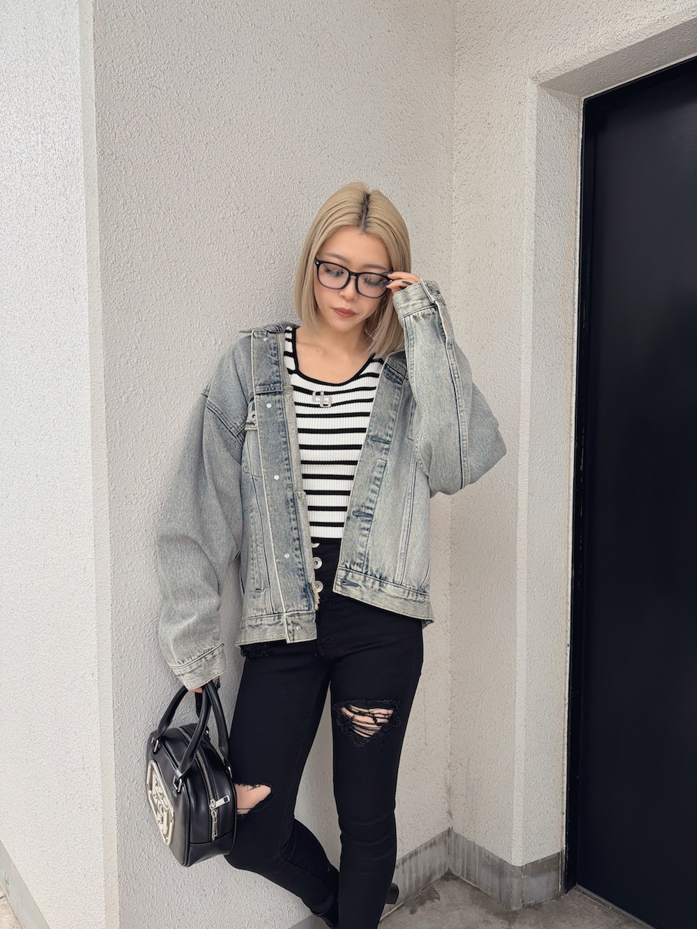 ブルー系のデニムジャケット、その他のニット/セーター、ブラック系のデニムパンツを着用したレディースの春コーディネートの3枚目の写真