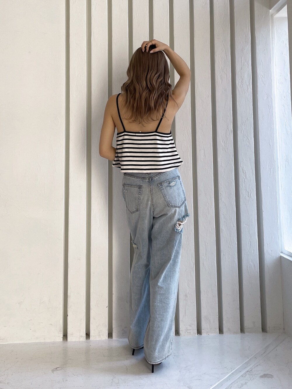 その他のキャミソール、ブルー系のデニムパンツ、ブラック系のパンプスを着用したレディースの春コーディネートの3枚目の写真