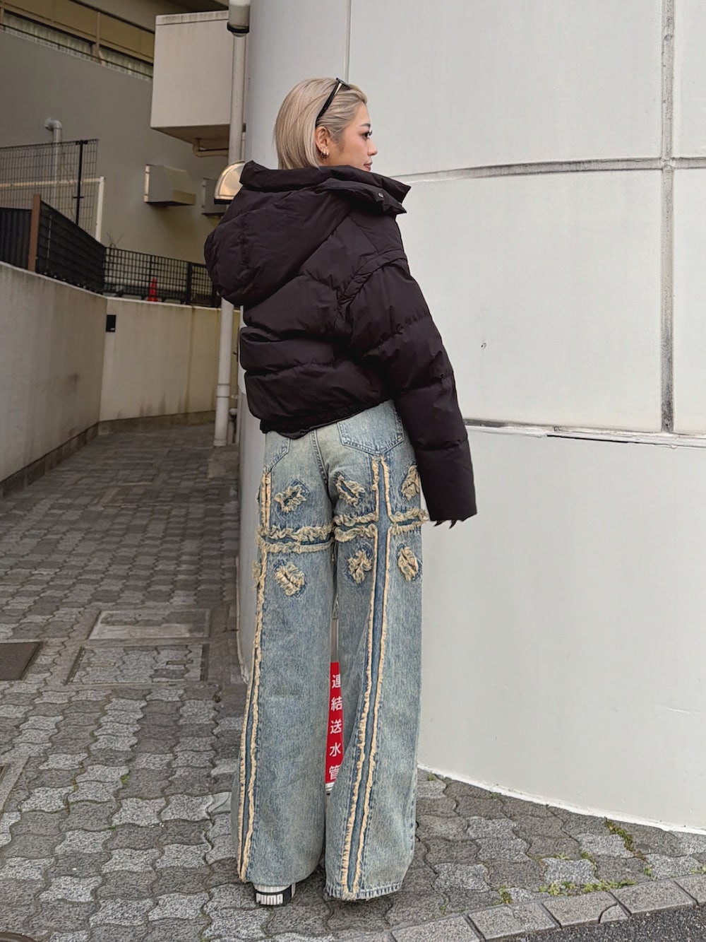 ブラック系のTシャツ/カットソー、ブルー系のデニムパンツを着用したレディースの冬コーディネートの2枚目の写真