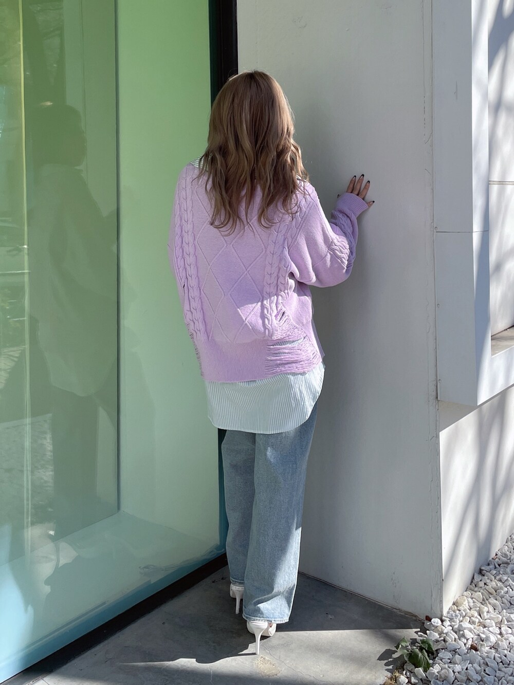 パープル系のニット/セーター、ブルー系のシャツ/ブラウス、ブルー系のデニムパンツを着用したレディースの冬コーディネートの2枚目の写真