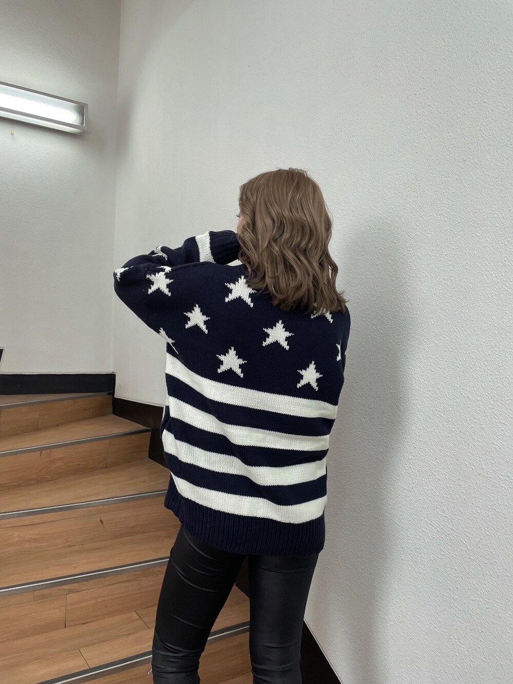 ブルー系のニット/セーター、ブラック系のその他パンツ、ホワイト系のパンプスを着用したレディースの冬コーディネートの5枚目の写真