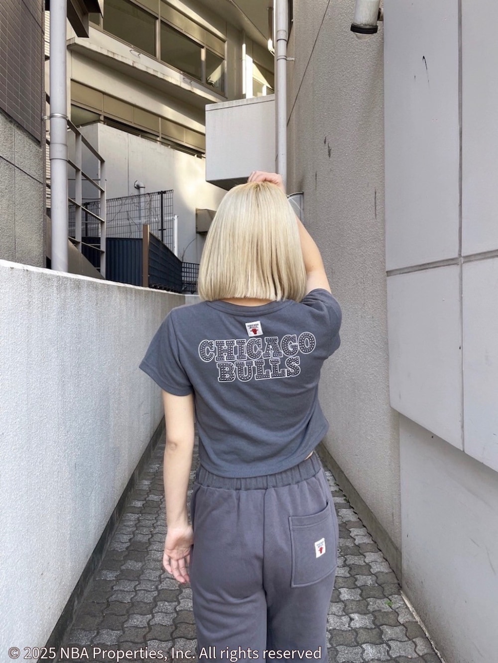 グレー系のTシャツ/カットソー、グレー系のスウェットパンツ、ブラック系のサンダルを着用したレディースの夏コーディネートの4枚目の写真