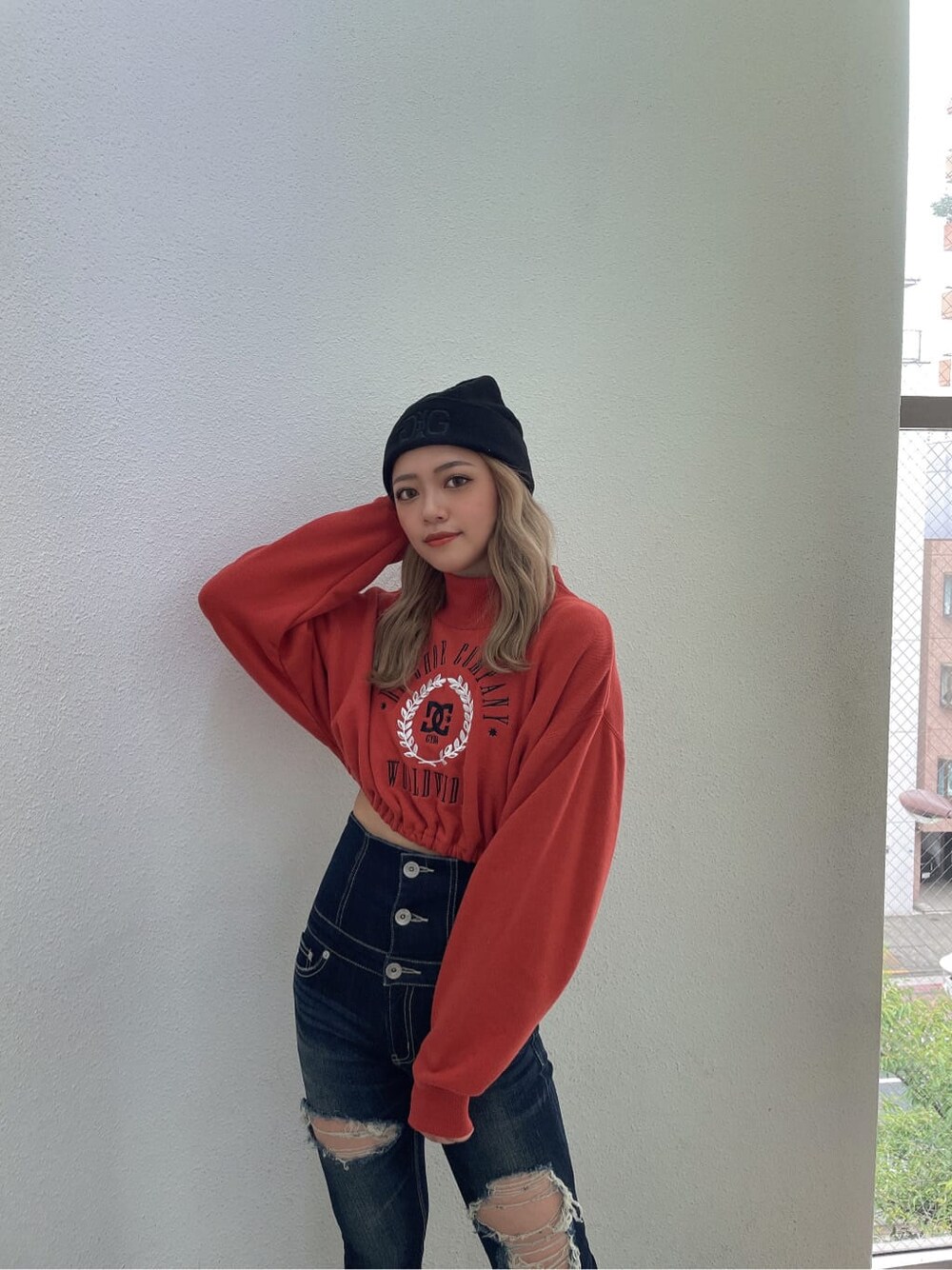 ブラック系のパンプス、ブルー系のデニムパンツ、オレンジ系のスウェットを着用したレディースの夏コーディネートの4枚目の写真