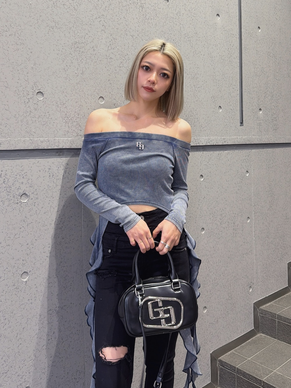 ブルー系のTシャツ/カットソー、ブラック系のハンドバッグ、ブラック系のデニムパンツを着用したレディースの春コーディネートの2枚目の写真