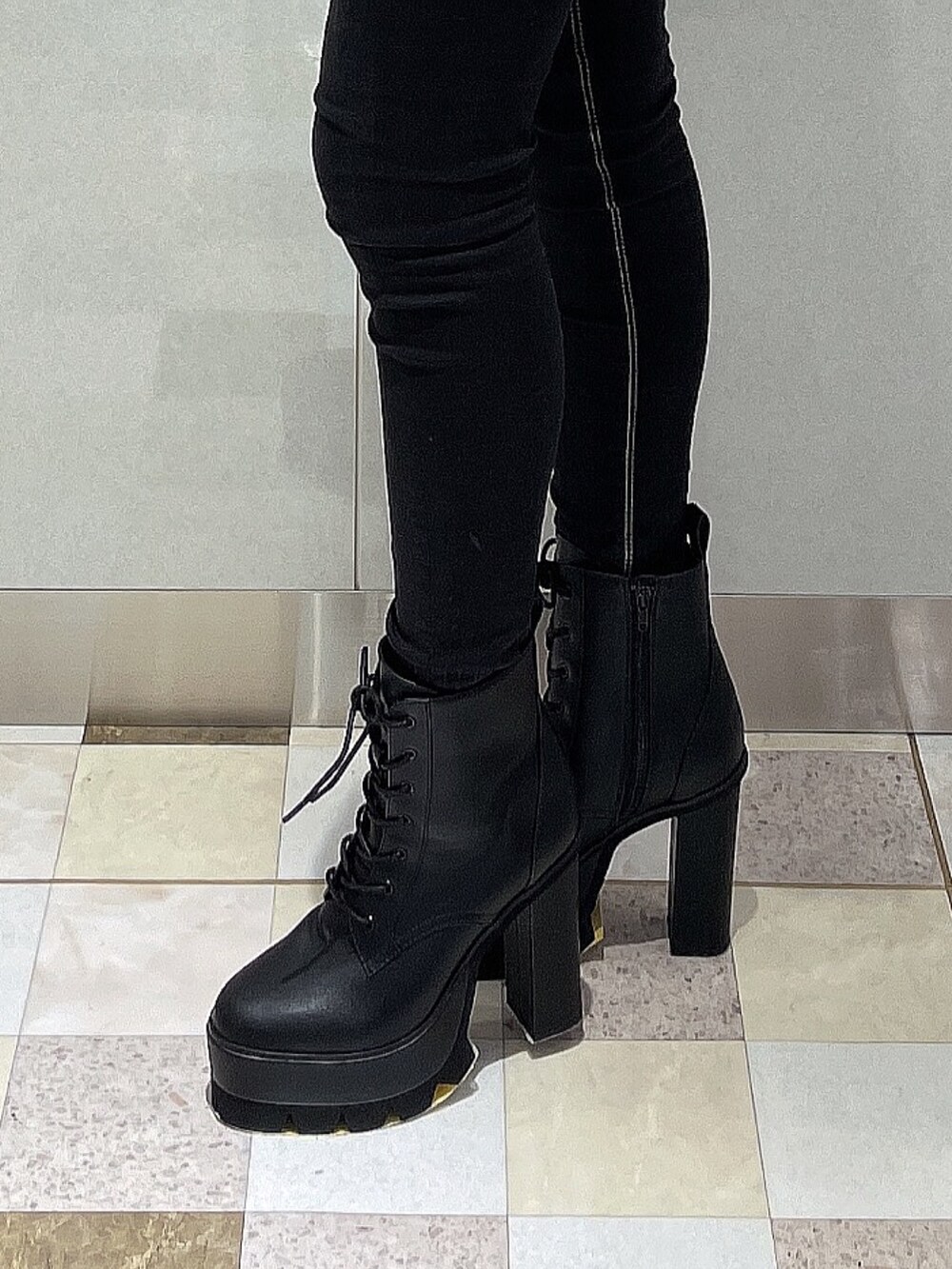 ホワイト系のニット/セーター、ブラック系のデニムパンツ、ブラック系のブーツを着用したレディースの秋コーディネートの6枚目の写真