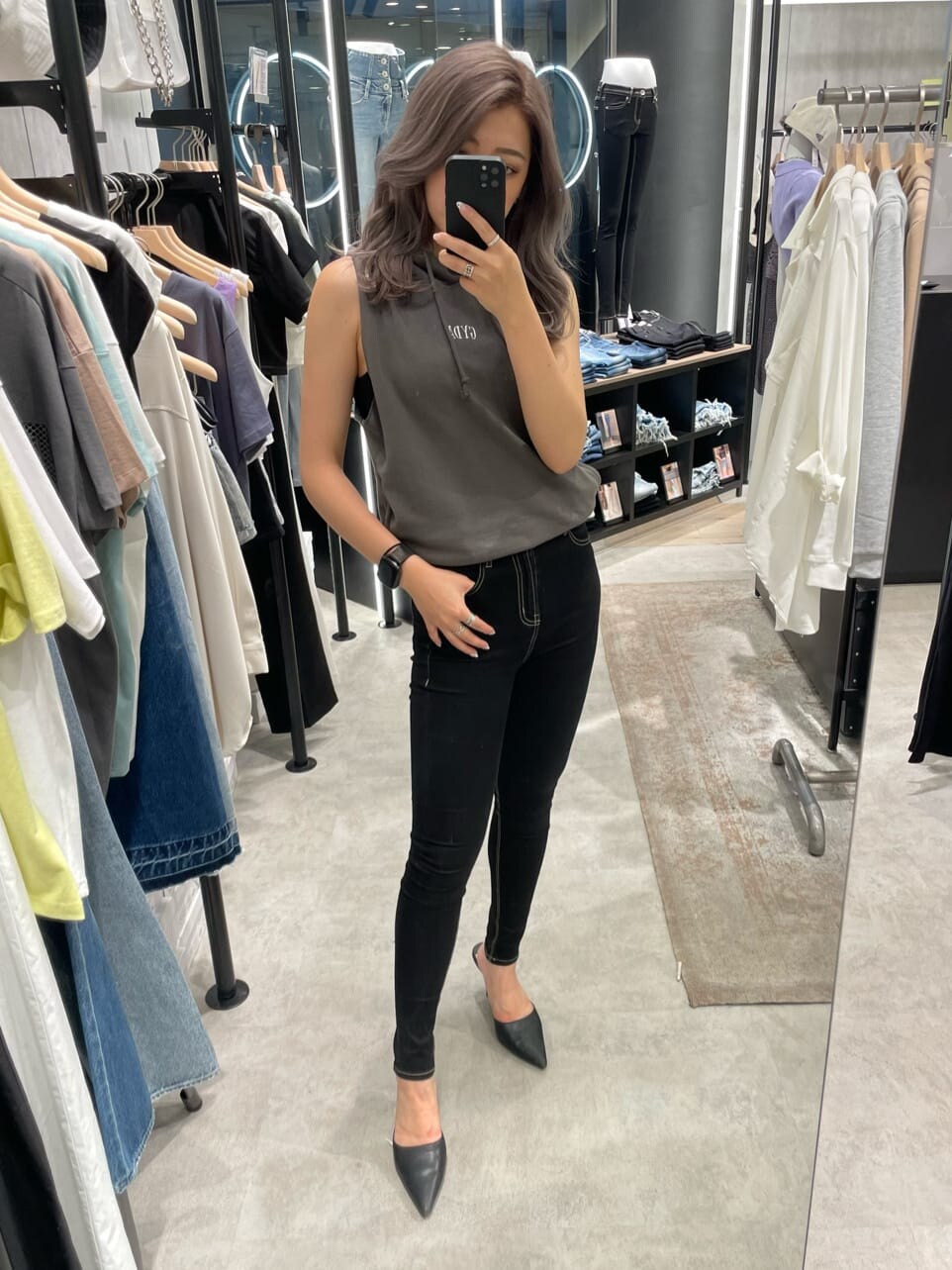 ブラック系のパンプス、グレー系のタンクトップ、ブラック系のデニムパンツを着用したレディースの夏コーディネートの4枚目の写真