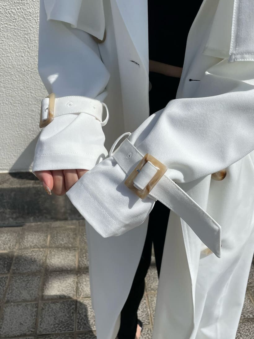 ブラック系のパンプス、ホワイト系のトレンチコートを着用したレディースの春コーディネートの8枚目の写真