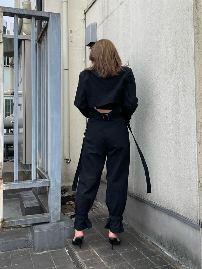 ブラック系のパンプス、ブラック系のスラックス、ブラック系のキャミソールを着用したレディースの春コーディネートの3枚目の写真