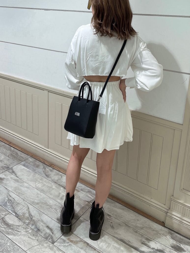 ホワイト系のワンピース、ブラック系のブーツ、ブラック系のショルダーバッグを着用したレディースの秋コーディネートの5枚目の写真