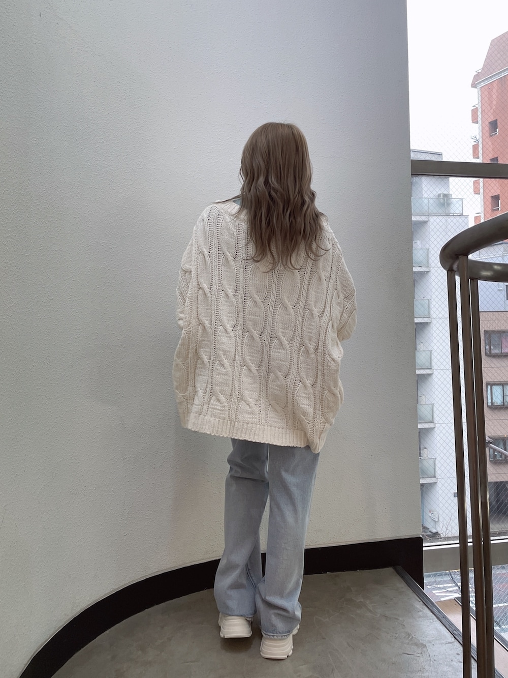 ホワイト系のカーディガン/ボレロ、グリーン系のTシャツ/カットソー、ブルー系のデニムパンツを着用したレディースの冬コーディネートの4枚目の写真