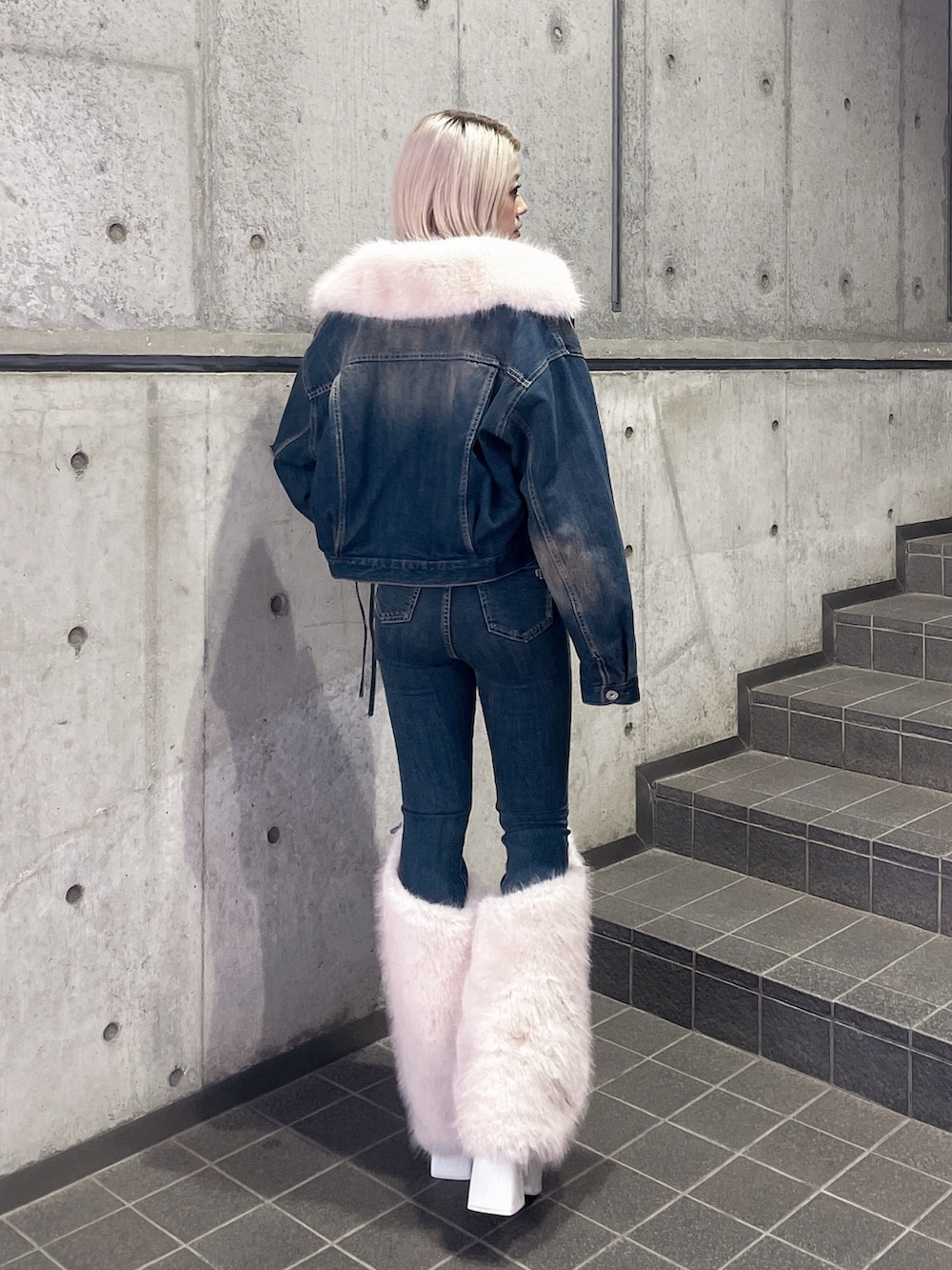 ブルー系のデニムジャケット、ブルー系のデニムパンツ、ホワイト系のブーツを着用したレディースの秋コーディネートの2枚目の写真