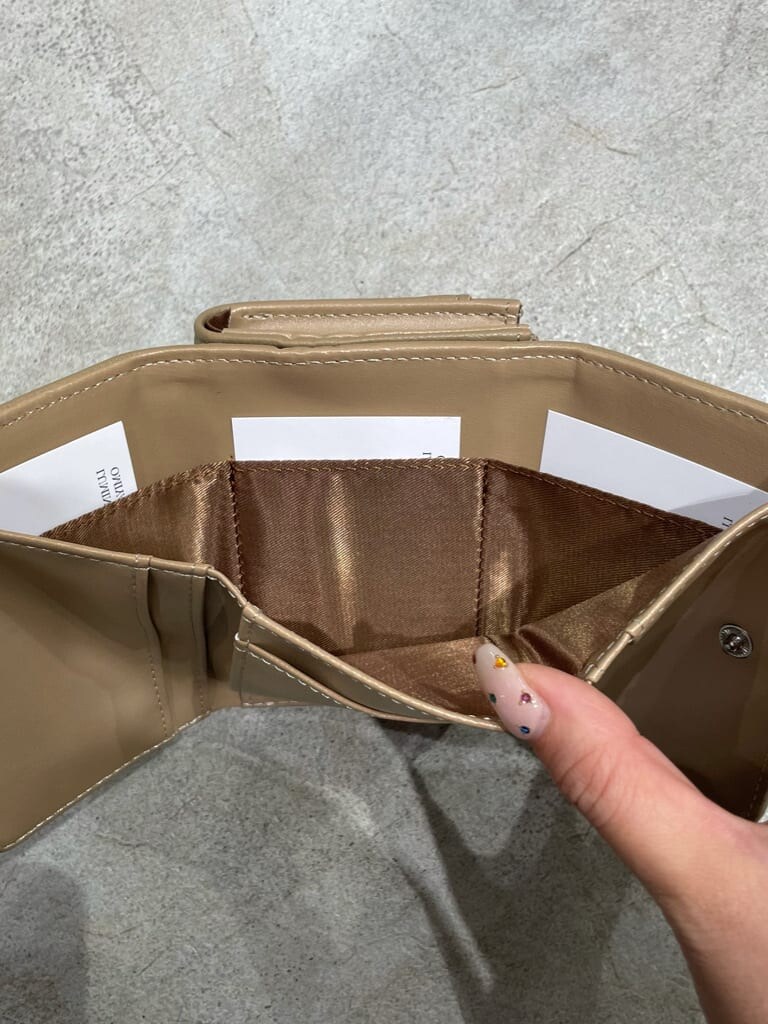 ベージュ系の財布を着用したレディースの秋コーディネートの5枚目の写真