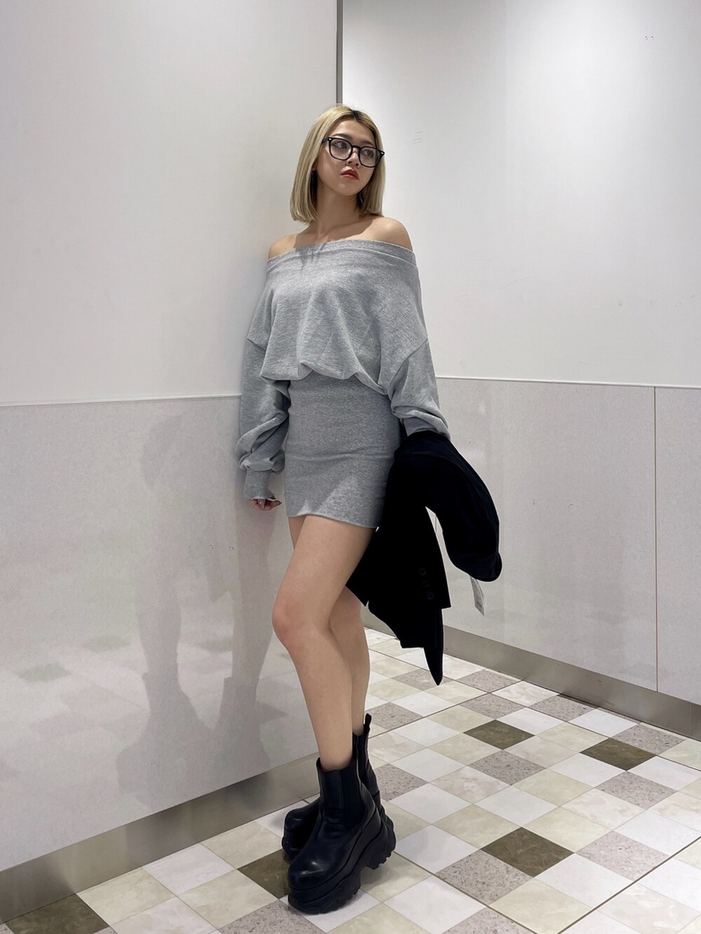 グレー系のワンピース、ブラック系のブーツを着用したレディースの冬コーディネートの2枚目の写真