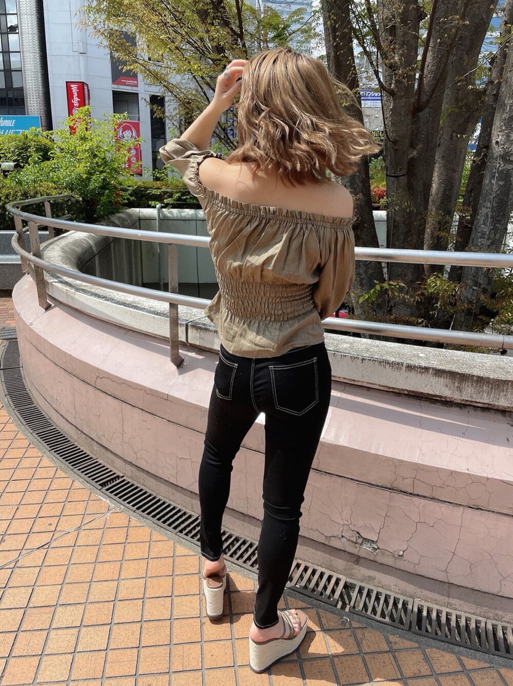 ブラック系のデニムパンツ、ベージュ系のシャツ/ブラウス、ベージュ系のサンダルを着用したレディースの春コーディネートの2枚目の写真