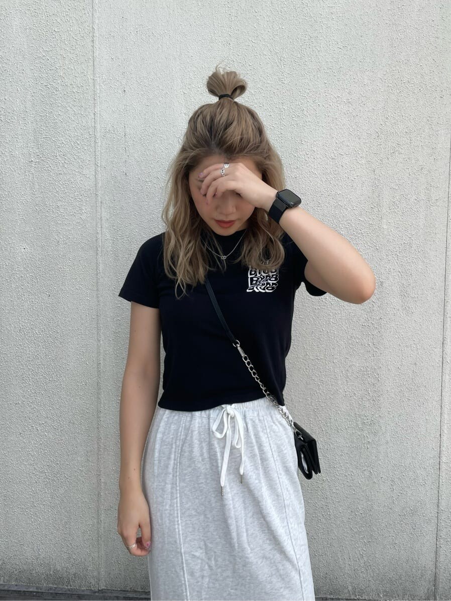 グレー系のスカート、ブラック系のTシャツ/カットソー、ブラック系の財布を着用したレディースの夏コーディネートの4枚目の写真