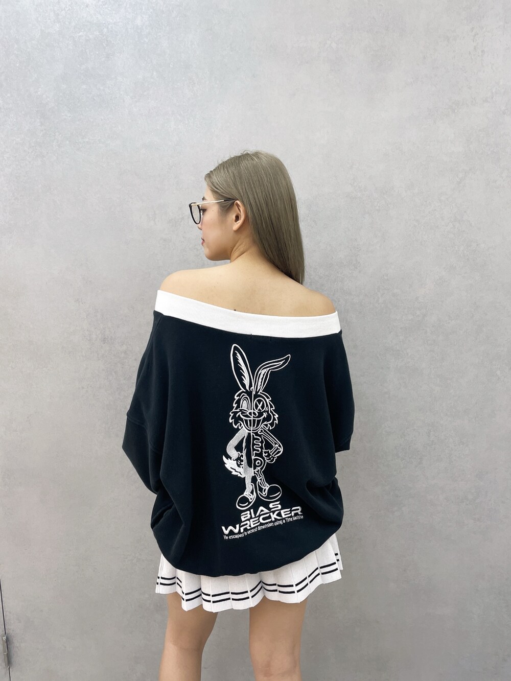 ブラック系のスウェット、ホワイト系のスカート、ブラック系のブーツを着用したレディースの冬コーディネートの4枚目の写真