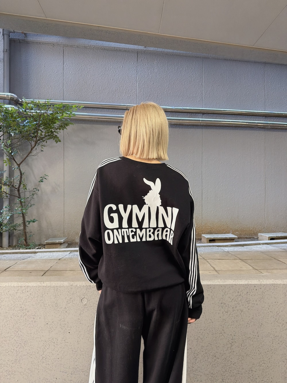 ブラック系のスウェットパンツ、ブラック系のスウェット、ブラック系のブーツを着用したレディースの冬コーディネートの4枚目の写真