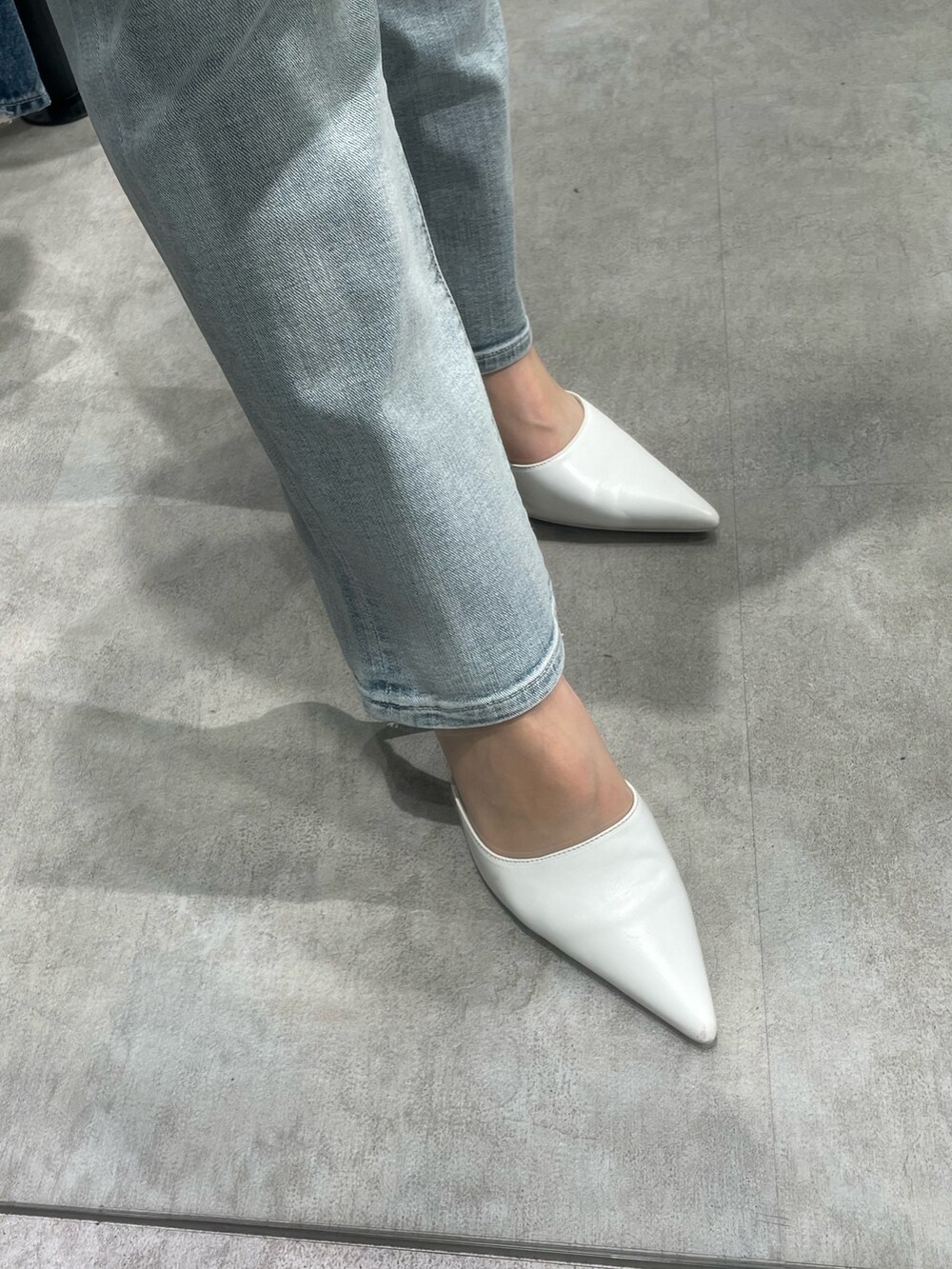 ホワイト系のシャツ/ブラウス、ブルー系のデニムパンツ、ホワイト系のパンプスを着用したレディースの冬コーディネートの8枚目の写真