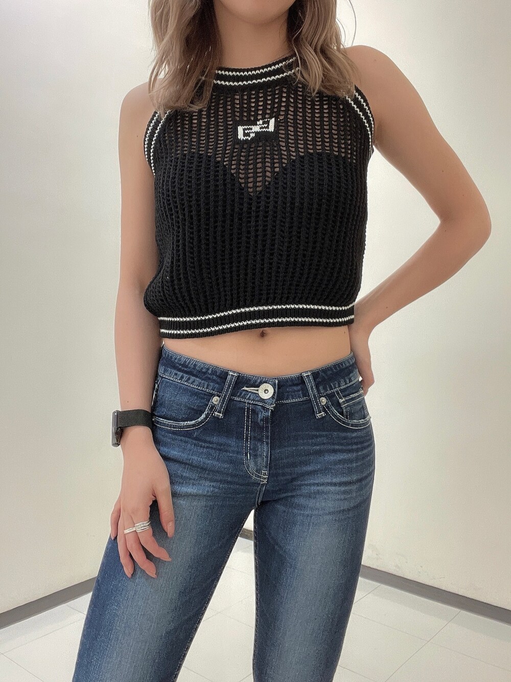 ブルー系のデニムパンツ、ブラック系のパンプス、ブラック系のニット/セーターを着用したレディースの夏コーディネートの5枚目の写真