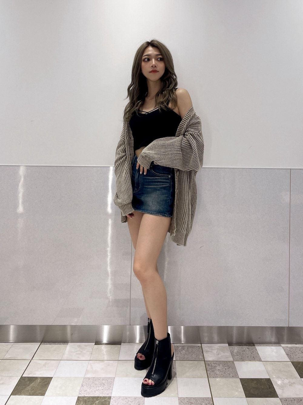 ブルー系のデニムスカート、ブラック系のブーツ、ベージュ系のカーディガン/ボレロを着用したレディースの夏コーディネートの2枚目の写真