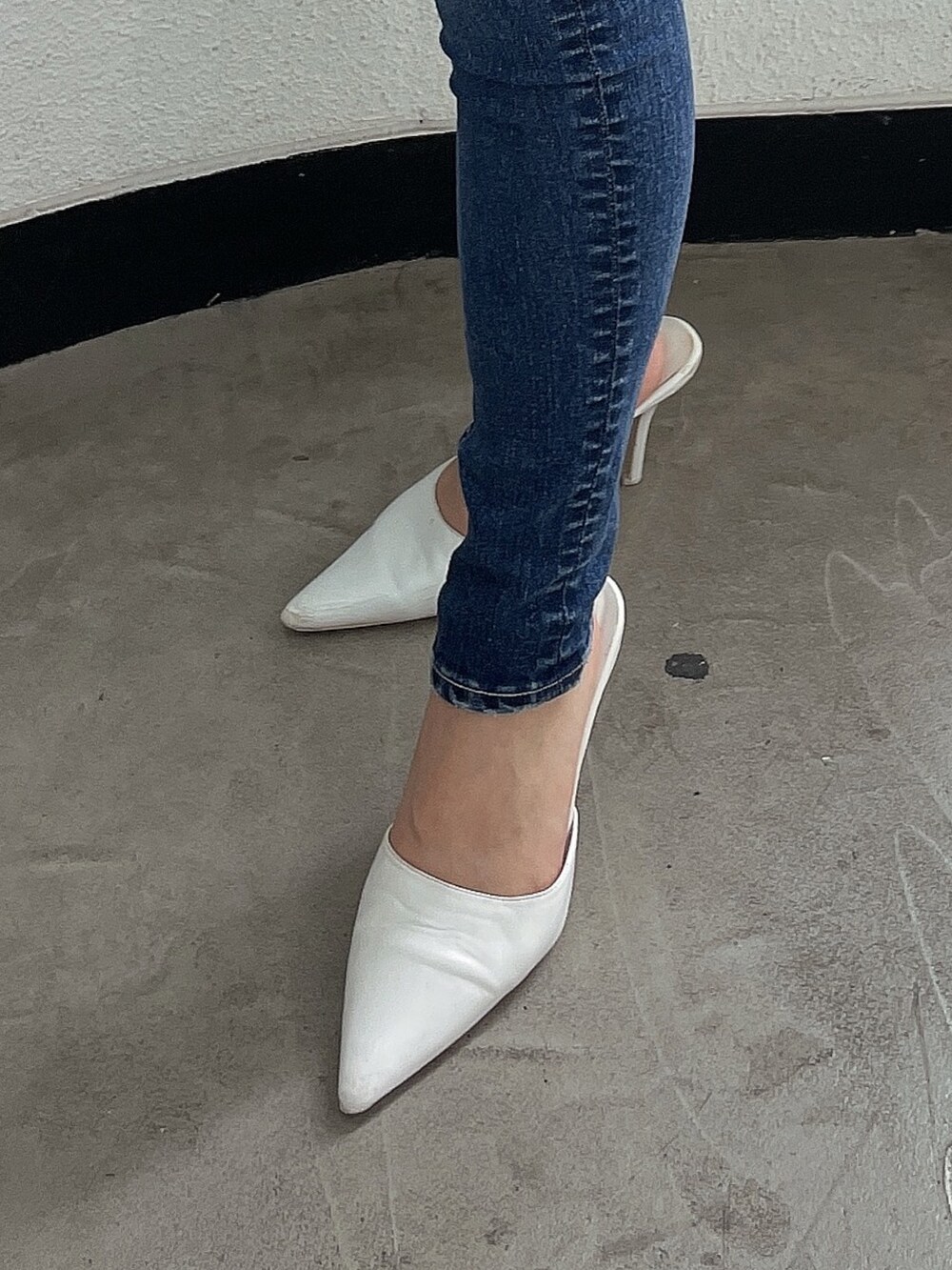 ブルー系のデニムパンツ、ホワイト系のパンプス、ホワイト系のニット/セーターを着用したレディースの夏コーディネートの6枚目の写真