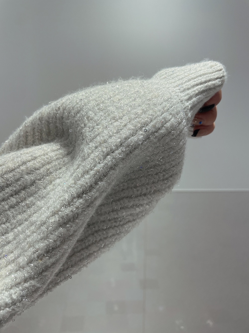 ホワイト系のニット/セーター、ブラック系のデニムパンツ、ブラック系のブーツを着用したレディースの秋コーディネートの7枚目の写真