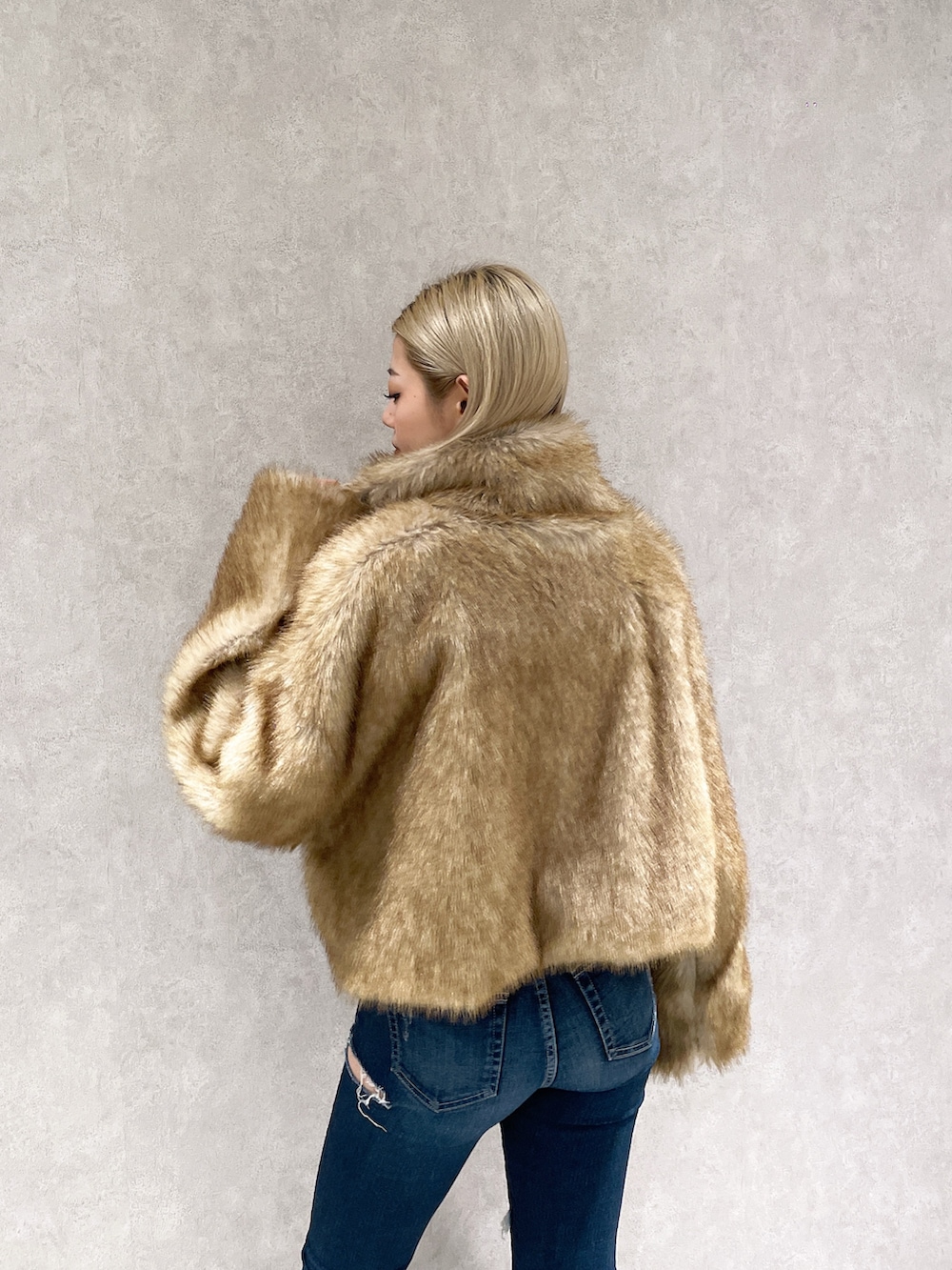 ベージュ系のその他アウター、ホワイト系のニット/セーター、ブルー系のデニムパンツを着用したレディースの冬コーディネートの5枚目の写真