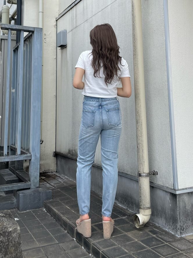 ホワイト系のサンダル、ホワイト系のTシャツ/カットソー、ブルー系のデニムパンツを着用したレディースの春コーディネートの2枚目の写真