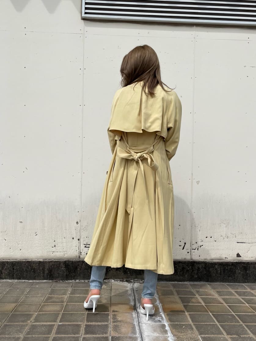 ホワイト系のパンプス、イエロー系のトレンチコート、ホワイト系のハンドバッグを着用したレディースの春コーディネートの3枚目の写真
